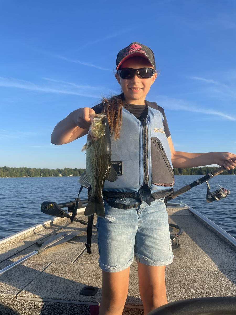 Angler holding a fish aboard the boat during a guided fishing trip in Maine